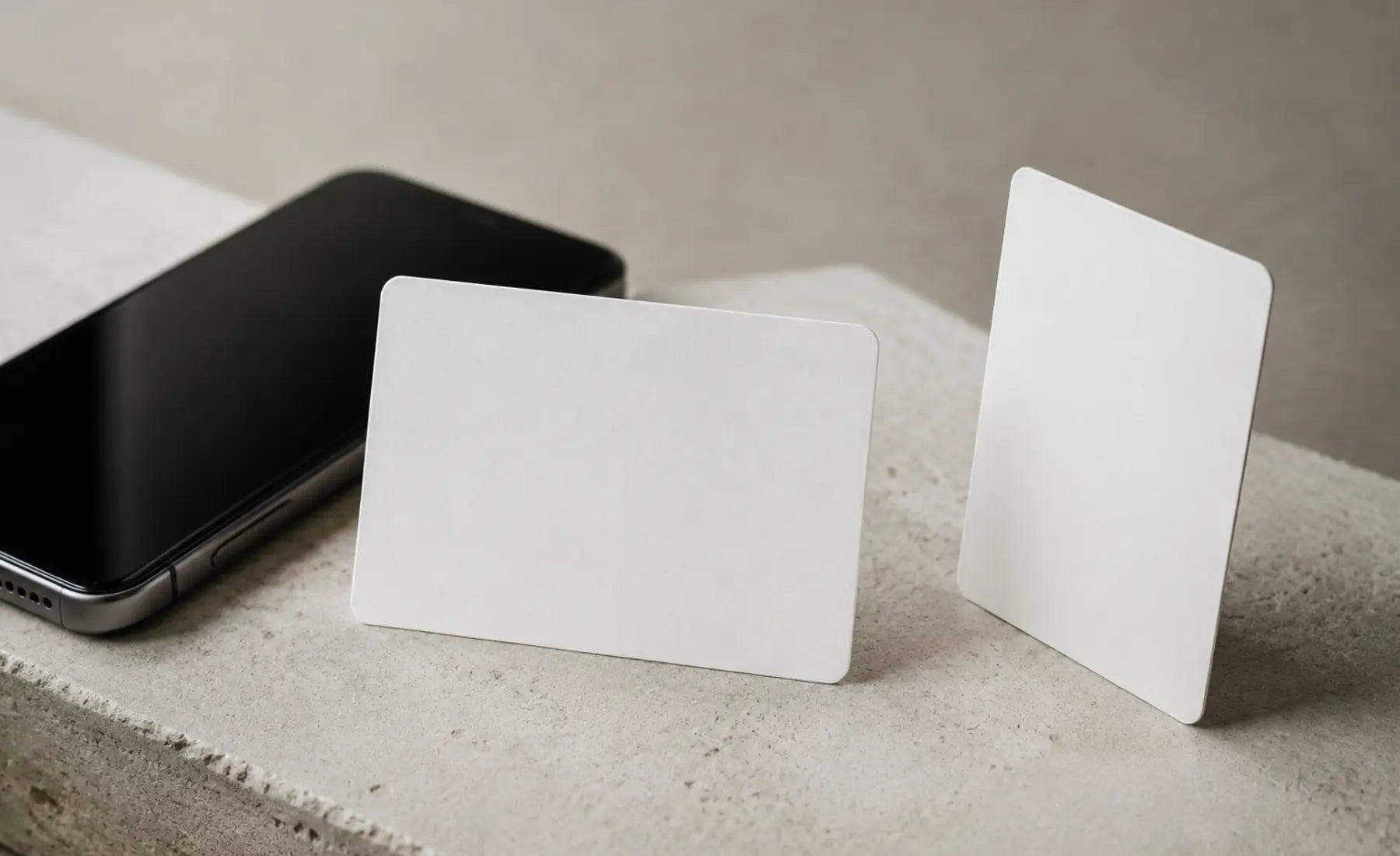 Two blank matte cards beside a phone
