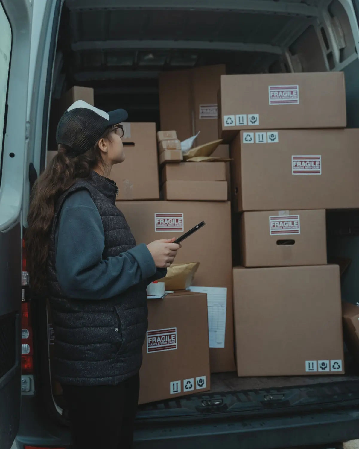 Delivery worker loading boxes into an unbranded van