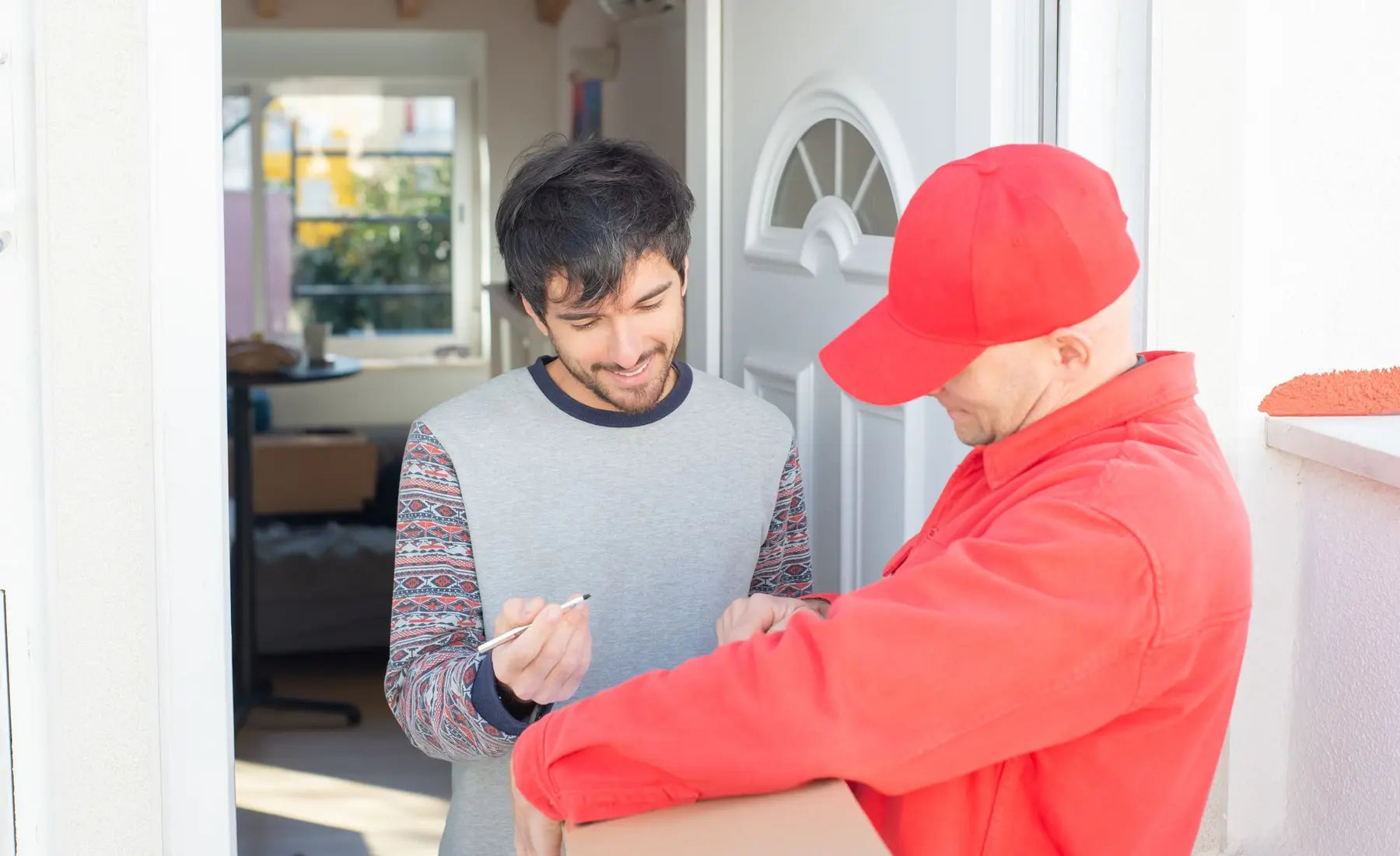 Recipient signing for a delivery at the doorway