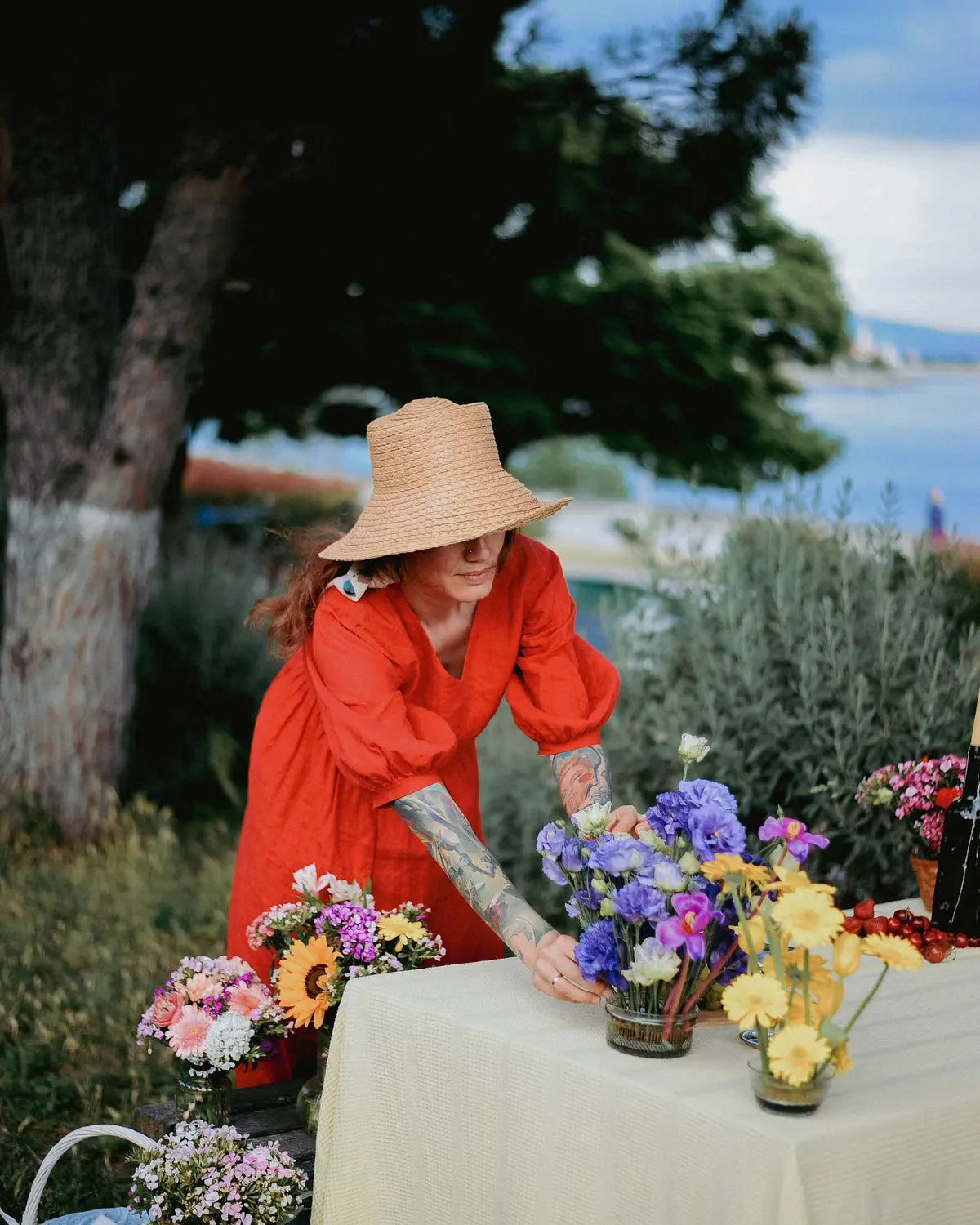 Person arranging colourful flowers on an outdoor event table
